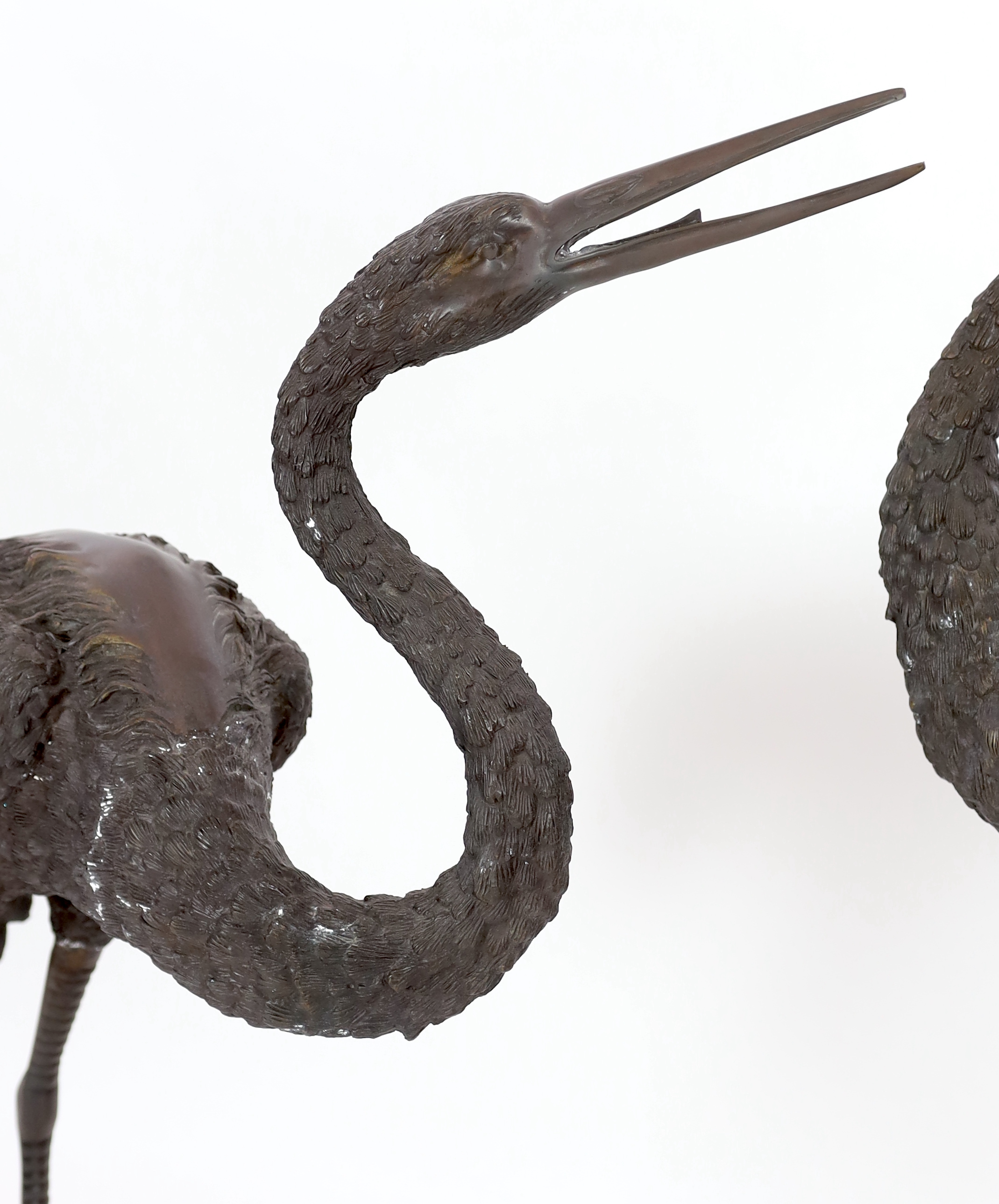 A pair of 20th century Chinese bronze garden models of cranes, 140cm and 157cm high